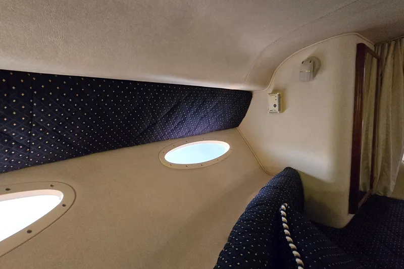 Slide: The Image of Interior cabin of 2001 Sea Ray 310 Sundancer with portholes and cushioned seating. - 48