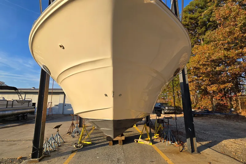 Slide: The Image of 2001 Sea Ray 310 Sundancer boat on dry dock, surrounded by autumn trees and clear sky. - 5