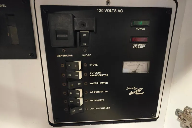 Slide: The Image of Electrical control panel of 2001 Sea Ray 310 Sundancer boat, showing switches and indicators. - 51