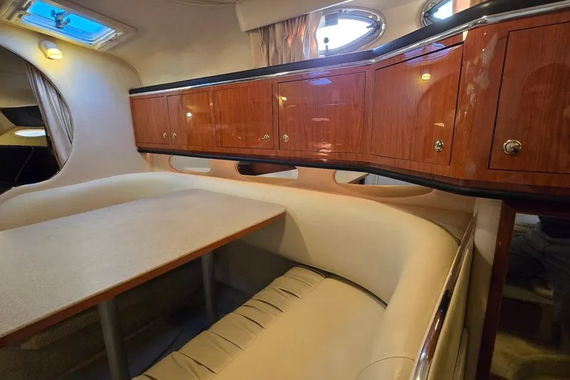 Slide: The Image of 2001 Sea Ray 310 Sundancer cabin interior with wooden cabinets and dining area. - 53