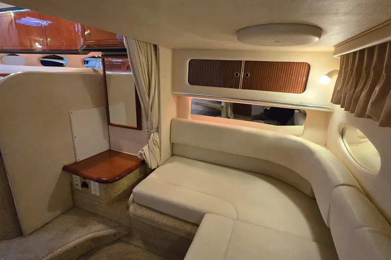 Slide: The Image of Interior of 2001 Sea Ray 310 Sundancer yacht with cozy seating and wooden cabinetry. - 57