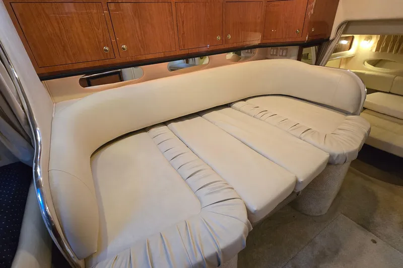Slide: The Image of Interior of 2001 Sea Ray 310 Sundancer with beige seating and wooden cabinets. - 62
