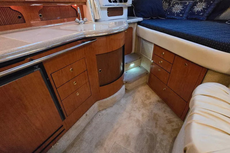 Slide: The Image of Interior of 2001 Sea Ray 310 Sundancer yacht with wood cabinetry and cozy seating area. - 63