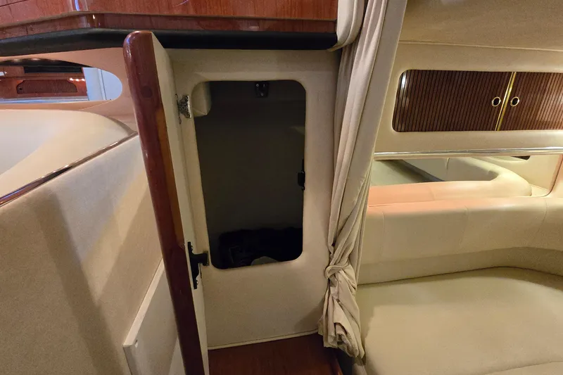 Slide: The Image of 2001 Sea Ray 310 Sundancer interior with open storage compartment and elegant wood finish. - 64