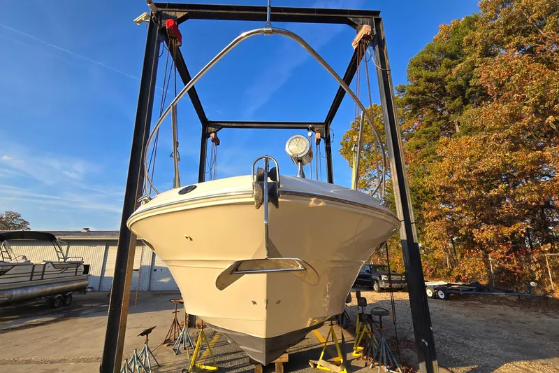 Slide: The Image of 2001 Sea Ray 310 Sundancer boat on lift, surrounded by autumn trees and clear blue sky. - 7