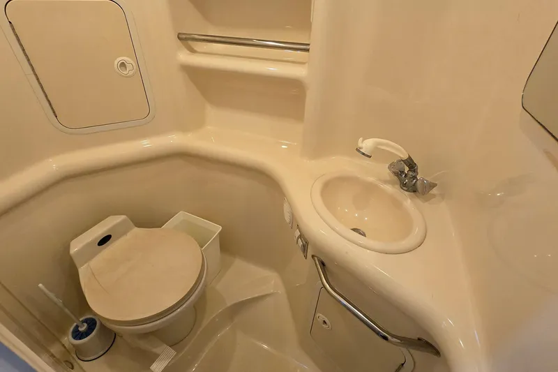 Slide: The Image of 2001 Sea Ray 310 Sundancer bathroom with sink, toilet, and storage compartments. - 71