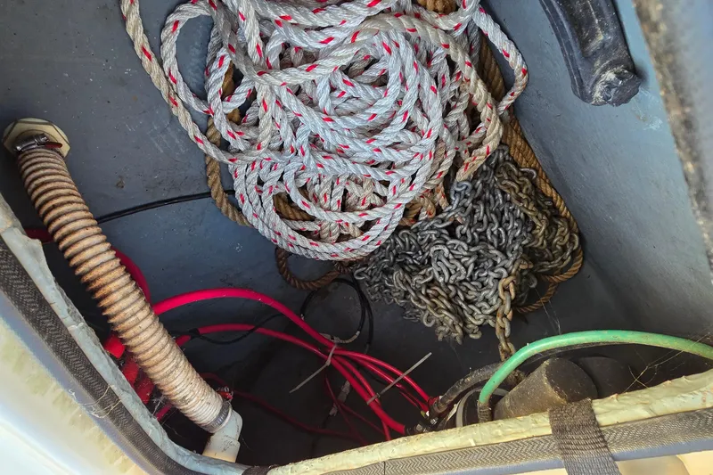 Slide: The Image of Storage compartment of 2001 Sea Ray 310 Sundancer with ropes, chains, and cables. - 84