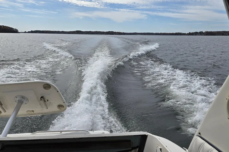 Slide: The Image of Wake behind a 2001 Sea Ray 310 Sundancer on a calm lake under a blue sky. - 93