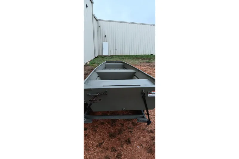 Slide: The Image of 2026 Tracker Grizzly 1436 Jon boat parked outdoors near a building. - 10