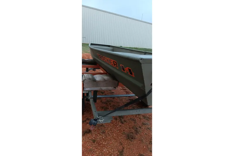 Slide: The Image of 2026 Tracker Grizzly 1436 Jon boat on trailer, parked outdoors. - 12