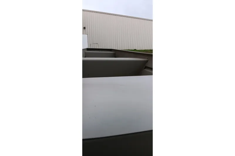 Slide: The Image of 2026 Tracker Grizzly 1436 Jon boat, close-up view, outdoors near a building. - 2