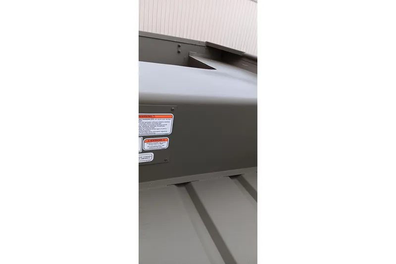 Slide: The Image of 2026 Tracker Grizzly 1436 Jon boat with visible warning labels and sleek design. - 7