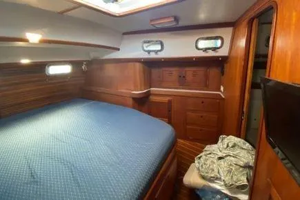 Slide: The Image of Cozy cabin interior of 1997 Freedom 45 yacht with wooden furnishings and blue bedding. - 10