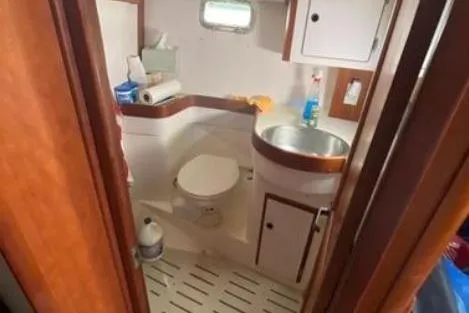 Slide: The Image of Compact bathroom in 1997 Freedom 45 yacht with sink, toilet, and storage cabinets. - 13
