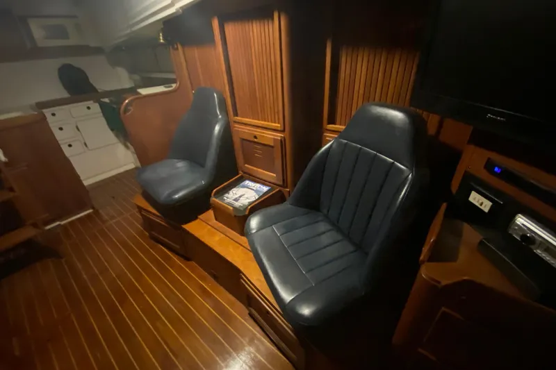 Slide: The Image of Interior of a 1997 Freedom 45 yacht with blue leather seats and wooden paneling. - 17