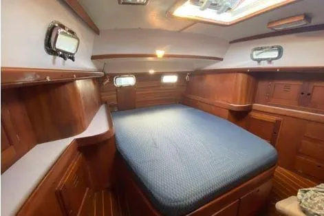 Slide: The Image of 1997 Freedom 45 yacht interior with wooden finish and cozy bed. - 9