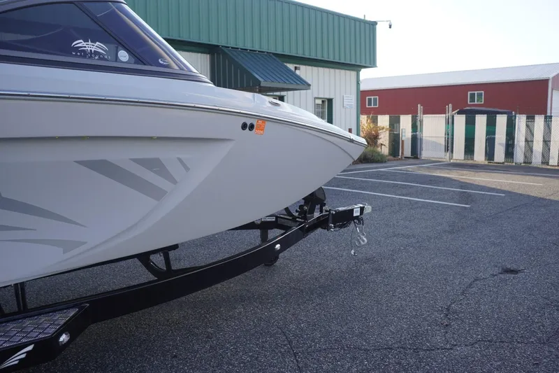 Slide: The Image of 2019 Tigé R20 boat on trailer in parking lot, near industrial buildings. - 45