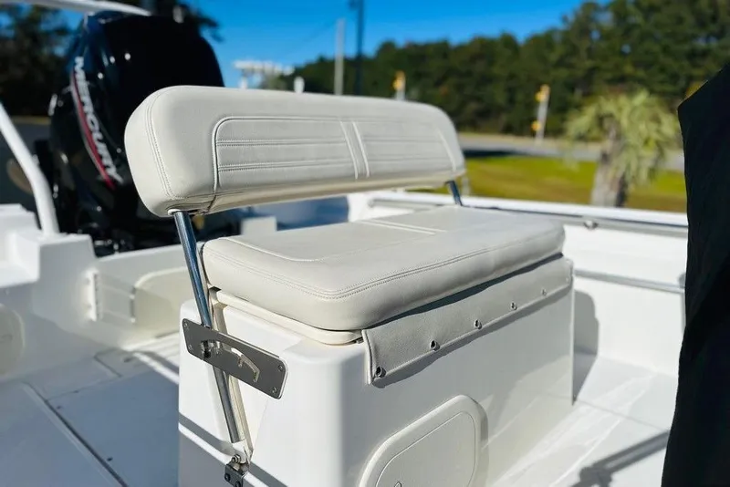 Slide: The Image of 2023 Boston Whaler 170 Montauk boat seat with Mercury engine in background. - 2