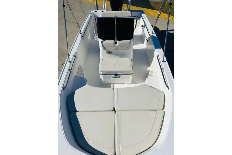 Slide: The Image of 2023 Boston Whaler 170 Montauk boat interior with cushioned seating and console. - 4