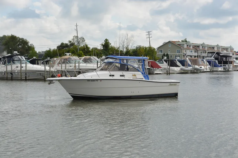 The Image of 2001 Shamrock 290 Walkaround boat docked in a marina with other vessels. - 0