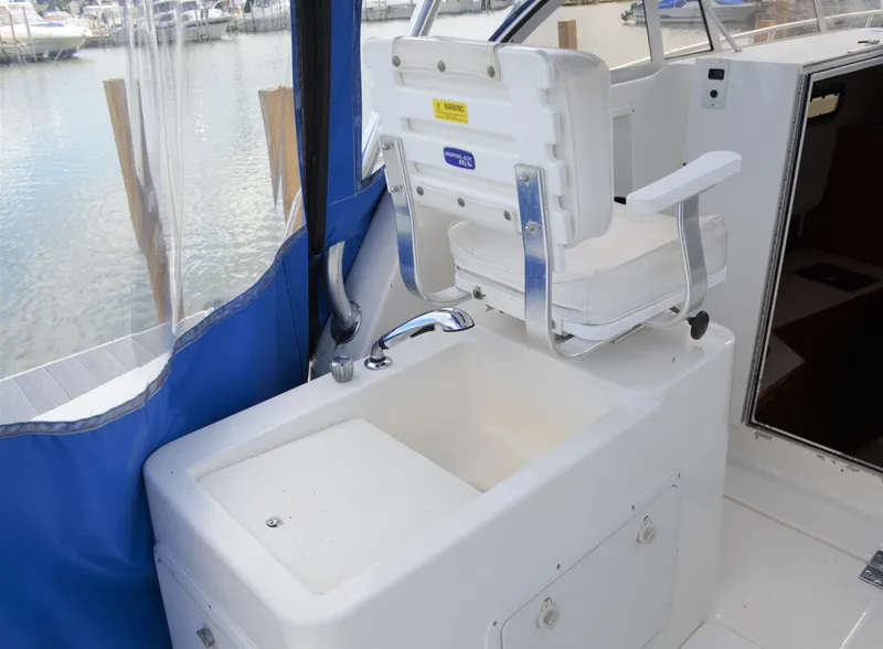 Slide: The Image of 2001 Shamrock 290 Walkaround boat interior with sink and seating area. - 12