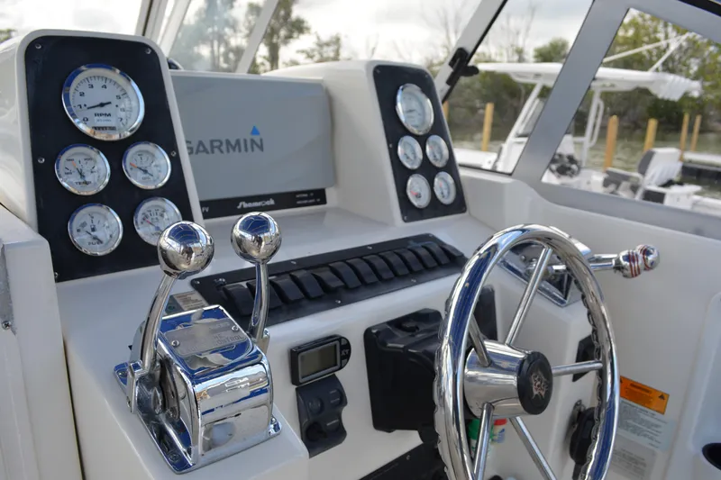 Slide: The Image of 2001 Shamrock 290 Walkaround helm with Garmin navigation, gauges, and dual throttle controls. - 14