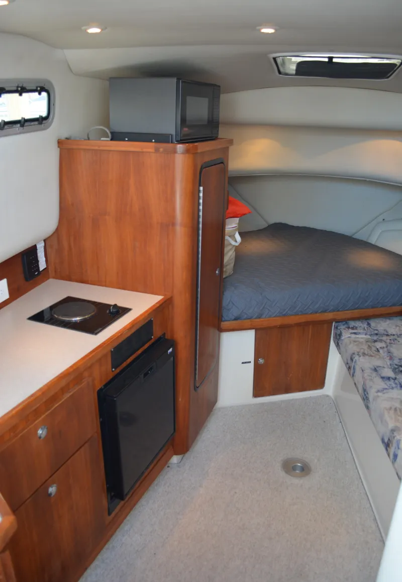 Slide: The Image of 2001 Shamrock 290 Walkaround cabin interior with kitchenette, bed, and storage. - 17