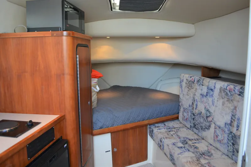 Slide: The Image of 2001 Shamrock 290 Walkaround cabin interior with bed, kitchenette, and seating area. - 18