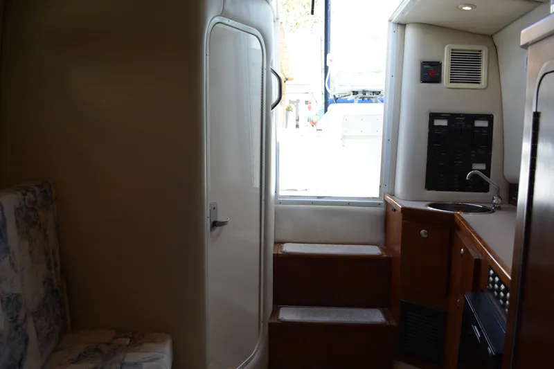 Slide: The Image of Interior of 2001 Shamrock 290 Walkaround boat, featuring stairs and compact kitchenette. - 21