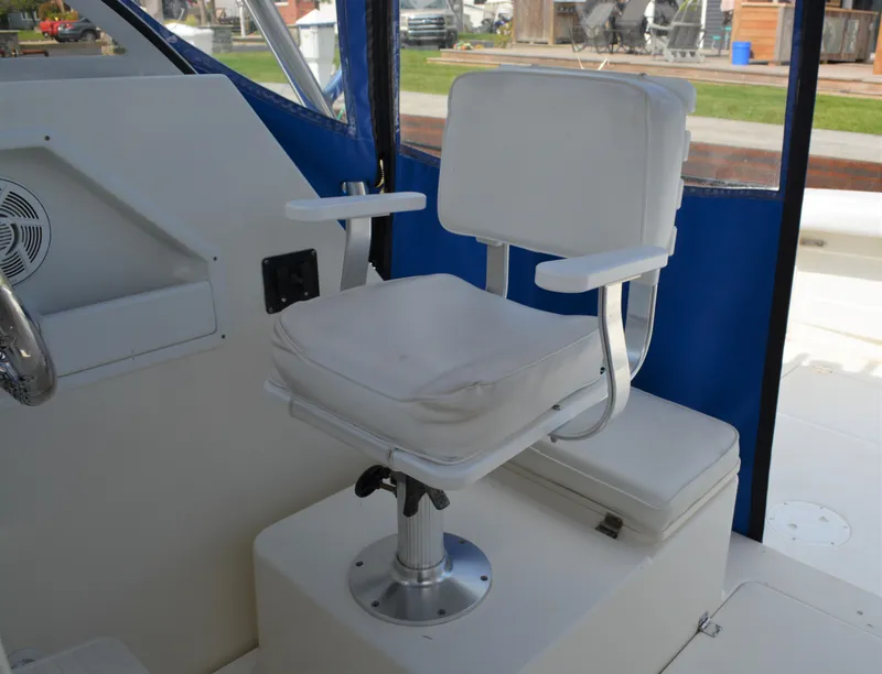 Slide: The Image of Captain's chair on 2001 Shamrock 290 Walkaround boat, featuring white upholstery and blue accents. - 25