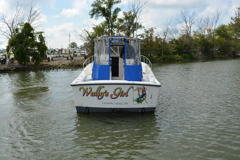 Slide: The Image of 2001 Shamrock 290 Walkaround boat named "Wally's Girl" on calm water near shore. - 6