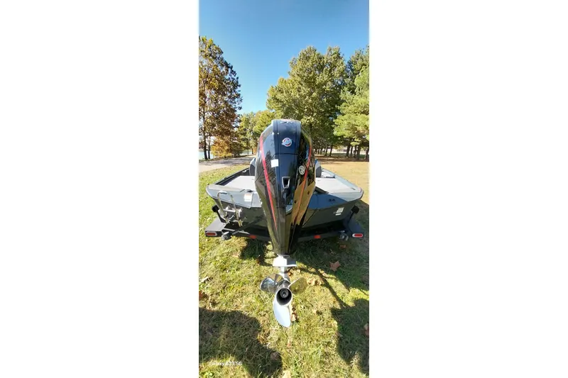 Slide: The Image of 2025 Ranger ALPHA 208 boat with outboard motor, parked on grass near trees. - 10