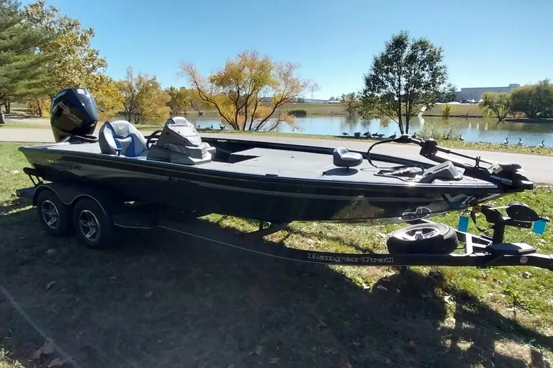 Slide: The Image of 2025 Ranger ALPHA 208 boat on trailer by a scenic lake. - 32