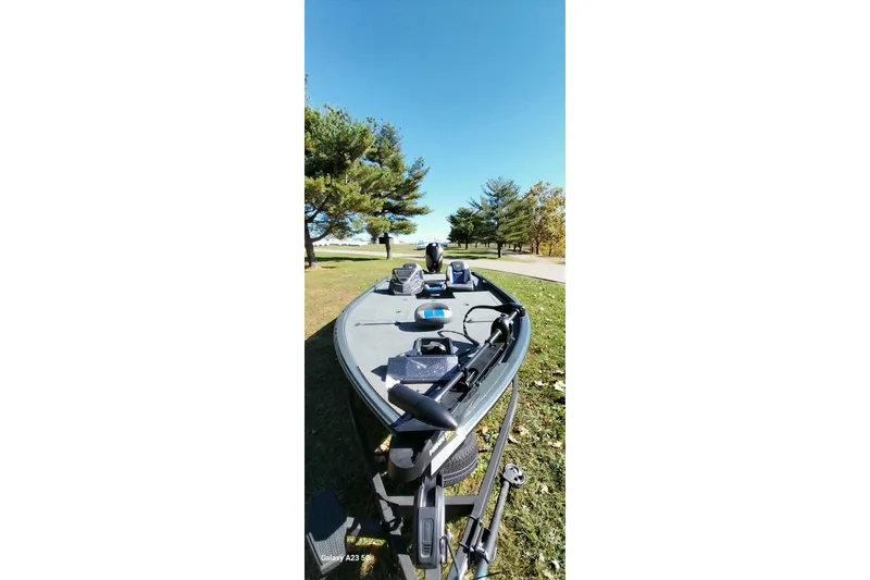 Slide: The Image of 2025 Ranger ALPHA 208 boat on grassy area with trees and clear sky. - 33