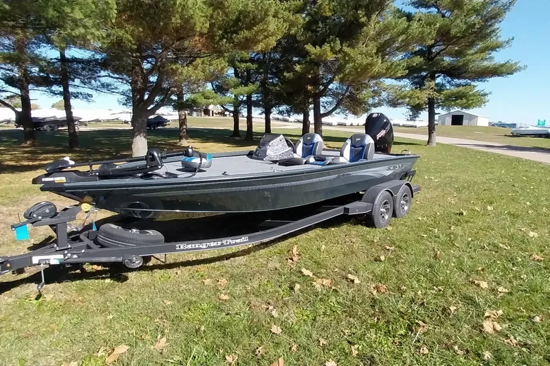 Slide: The Image of 2025 Ranger ALPHA 208 boat on trailer, parked on grassy area with trees. - 34