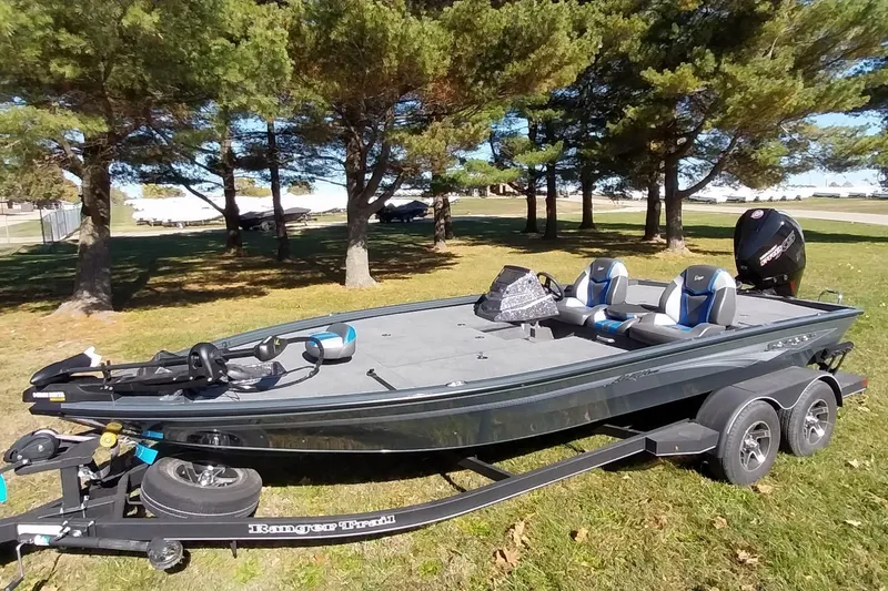 Slide: The Image of 2025 Ranger ALPHA 208 boat on trailer, parked on grass with trees in background. - 35