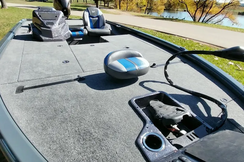 Slide: The Image of 2025 Ranger ALPHA 208 boat interior with seating and storage, near a scenic lake. - 6