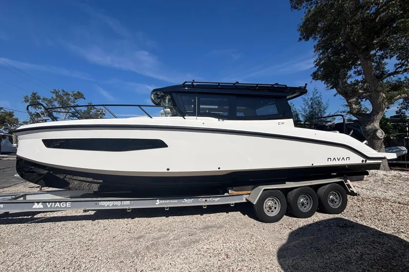 The Image of 2026 Navan C30 boat on trailer, sleek design, parked outdoors under clear blue sky. - 0