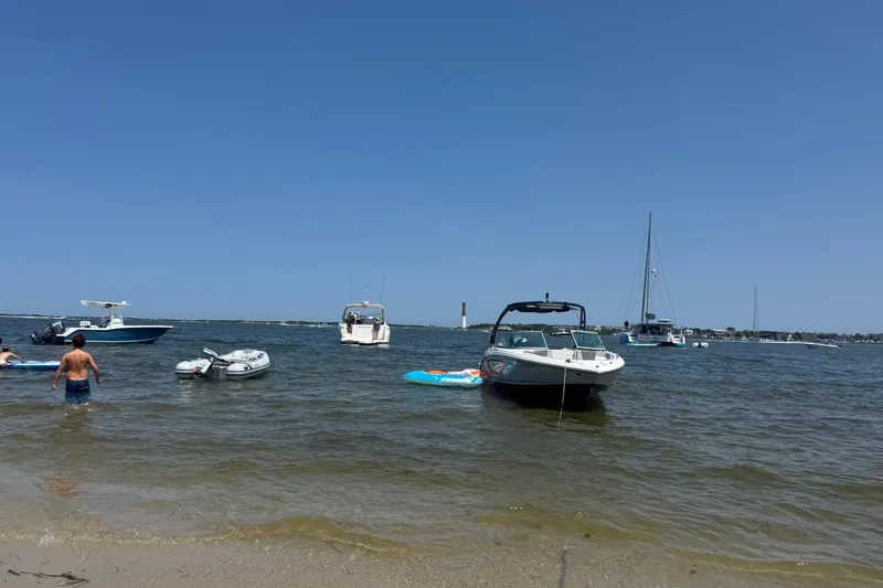 Slide: The Image of Boats anchored near shore, featuring a 2021 Chaparral 23 SSi under clear blue skies. - 10