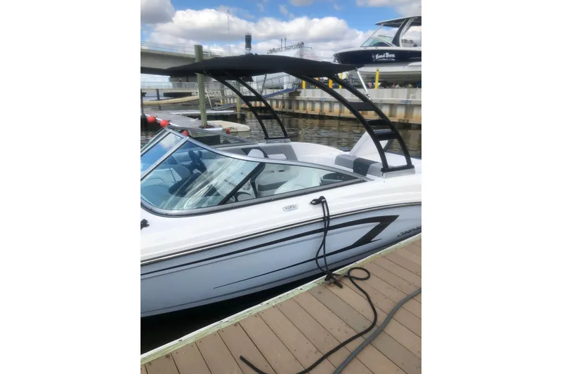 Slide: The Image of 2021 Chaparral 23 SSi boat docked, featuring sleek design and modern wakeboard tower. - 9
