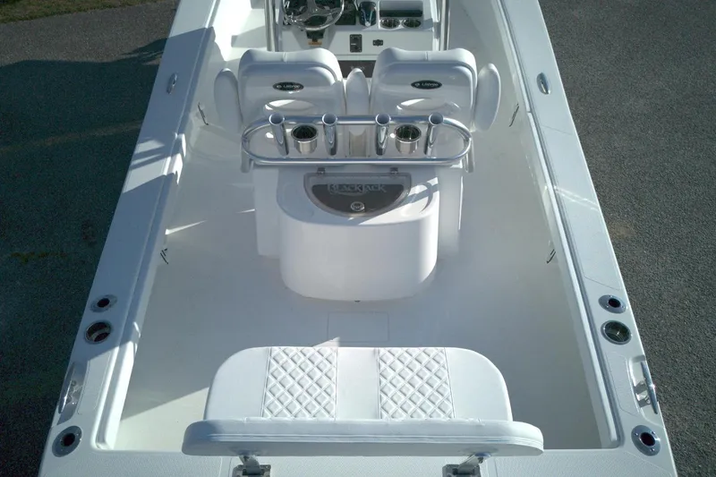 Slide: The Image of 2026 BlackJack 256 Coastal boat interior with white seating and fishing rod holders. - 11