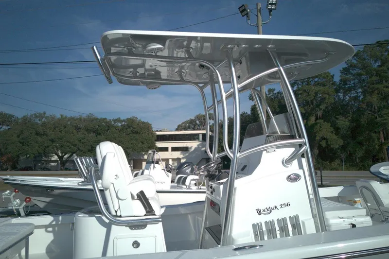 Slide: The Image of 2026 BlackJack 256 Coastal boat with T-top and seating, parked outdoors. - 7