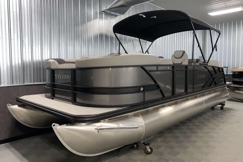 Slide: The Image of 2025 Sylvan L3 LZ pontoon boat in showroom with sleek design and canopy. - 13