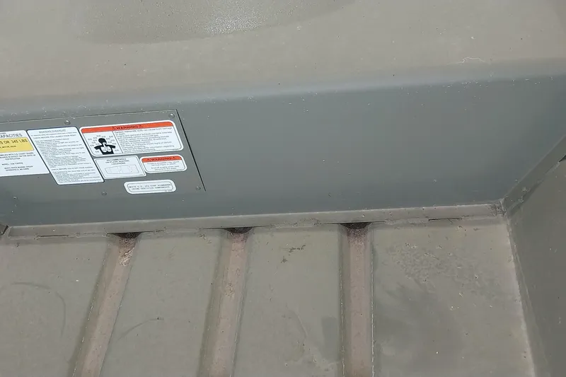 Slide: The Image of 2025 Tracker Grizzly 1436 Utility boat interior with safety labels visible. - 12