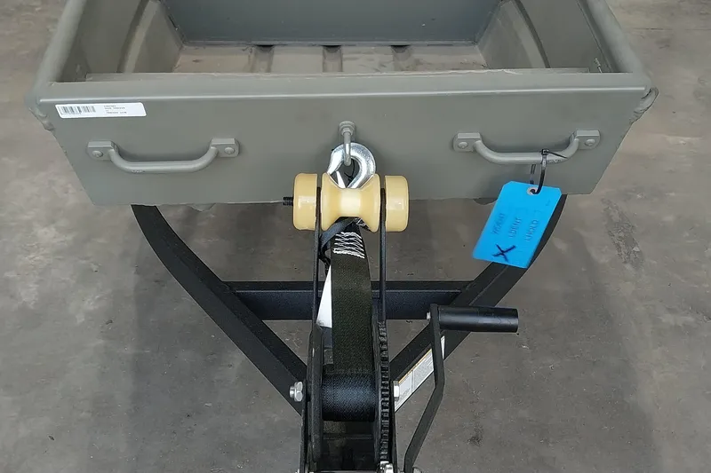 Slide: The Image of 2025 Tracker Grizzly 1436 Utility boat trailer hitch with blue tag and winch. - 4