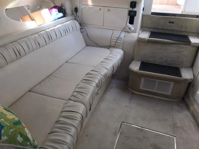 Slide: The Image of 1997 Sea Ray 330 Express Cruiser interior with beige seating and steps. - 10