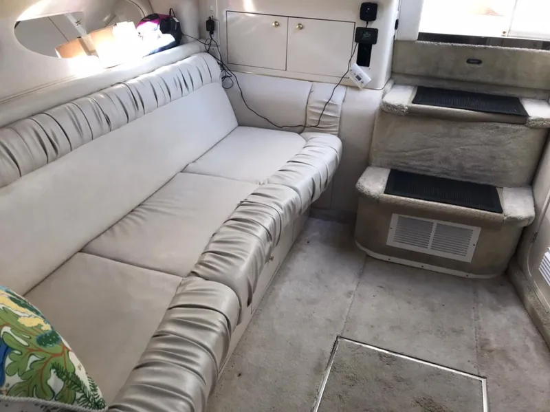 Slide: The Image of 1997 Sea Ray 330 Express Cruiser interior with beige seating and steps. - 11