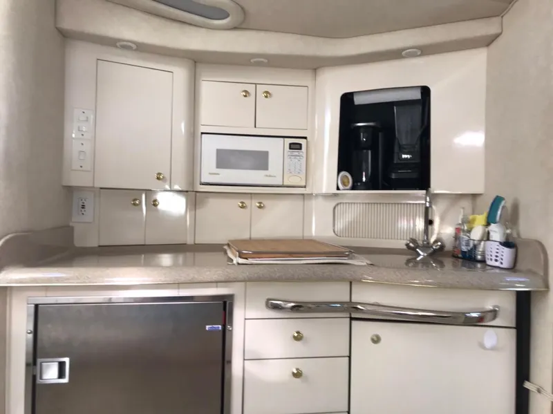 Slide: The Image of 1997 Sea Ray 330 Express Cruiser kitchen with microwave, coffee maker, and storage cabinets. - 13