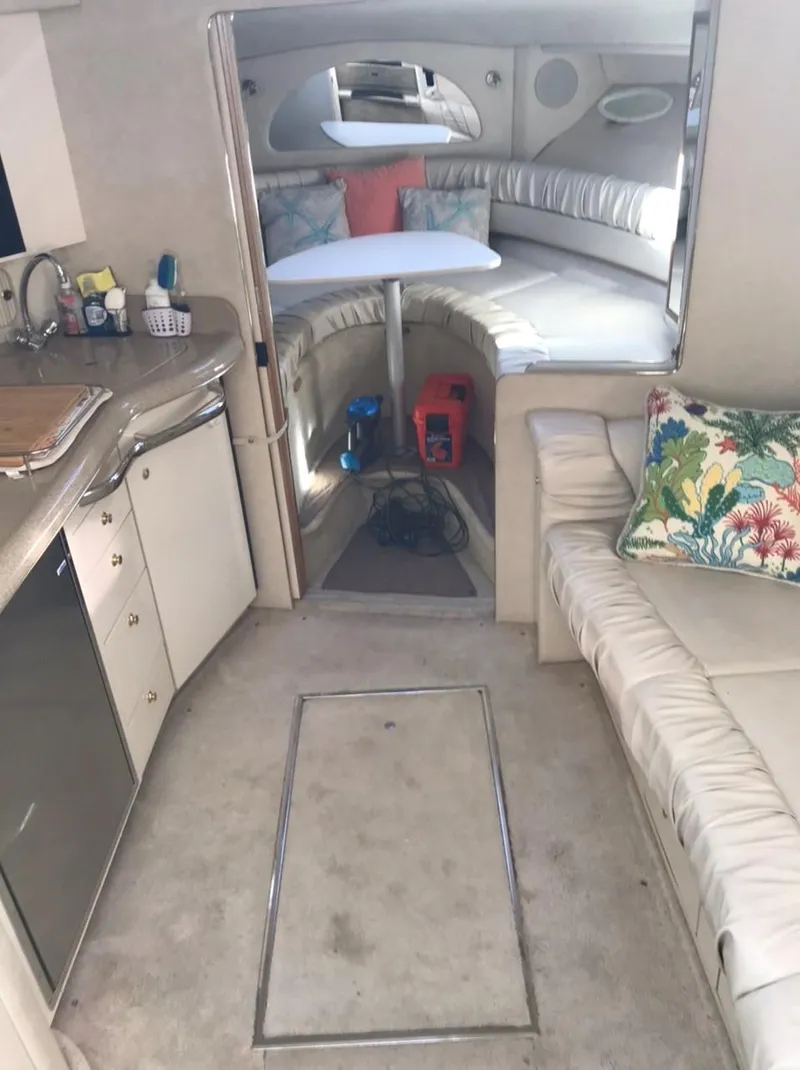 Slide: The Image of Interior of 1997 Sea Ray 330 Express Cruiser with seating, kitchenette, and cozy cabin area. - 16