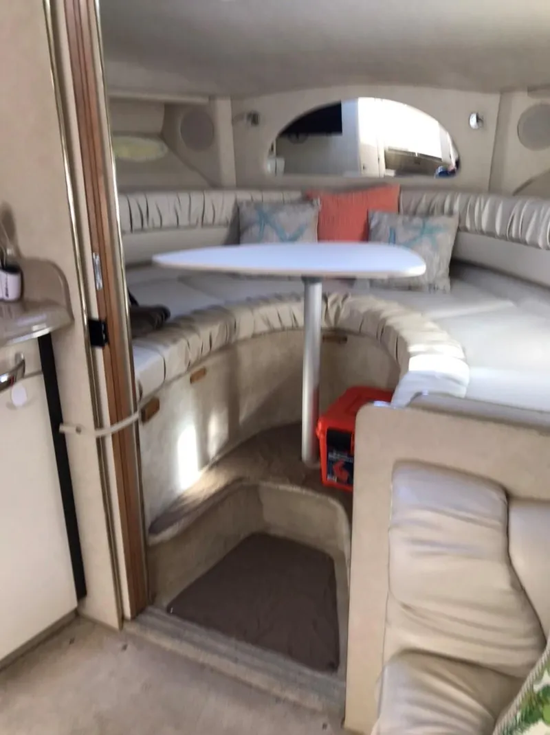 Slide: The Image of 1997 Sea Ray 330 Express Cruiser cabin with seating and table. - 17